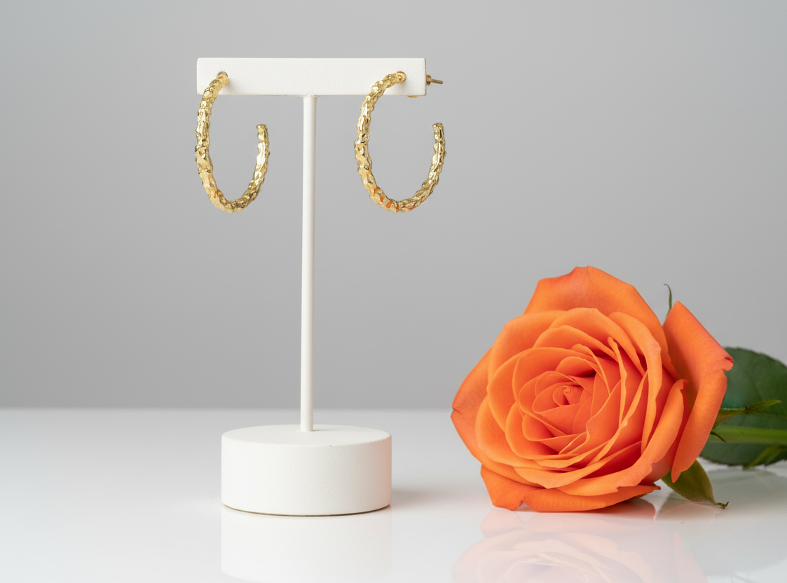 Gold textured hoop earrings pair with full orange rose