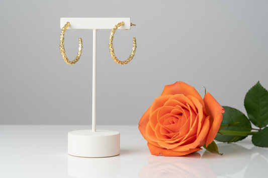 Gold textured hoop earrings pair with full orange rose